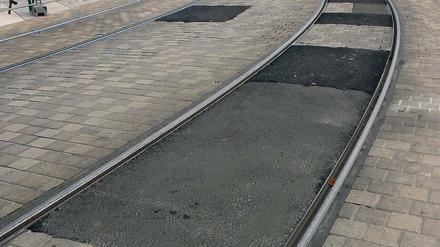 Seltsames Mosaik. Die verschlissenen Pflastersteine wurden nicht ersetzt. Provisorisch wurde die Nahverkehrsstraße am Landtagsschloss mit Asphalt geflickt. Wie lang es so bleiben soll, ist noch unklar.
