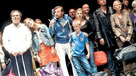 Das Glück in der Gemeinschaft. Daniel Daréus (Raphael Rubino, l.) und Lena (Elzemarieke de Vos, 2.v.l.) warten mit den anderen Chormitgliedern auf den Bus nach Wien. Tore (Alexander Finkenwirth, 3.v.l.) sorgt derweil für Unterhaltung.