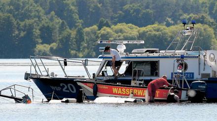 Bergung. Polizei und Wasserwacht am Wrack des Segelbootes.