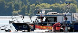 Bergung. Polizei und Wasserwacht am Wrack des Segelbootes.
