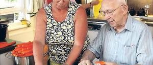Wie in einer Familie. Doris Grunow bereitet das Mittagessen für die Hausgemeinschaft vor: Bewohner helfen ihr beim Schneiden von Kartoffeln, Möhren und Zwiebeln.