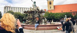 Alltag und Ausnahmezustand. Zwei Tage nach dem tödlichen Schuss posieren Touristen vor dem Neptunbrunnen, Kerzen erinnern an das Opfer.