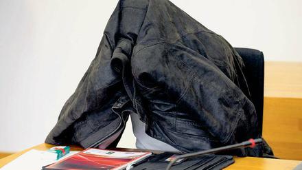 Verquerung der Tatsachen. Der Angeklagte Marcus B. versteckt sich vor den Kameras im Gericht.