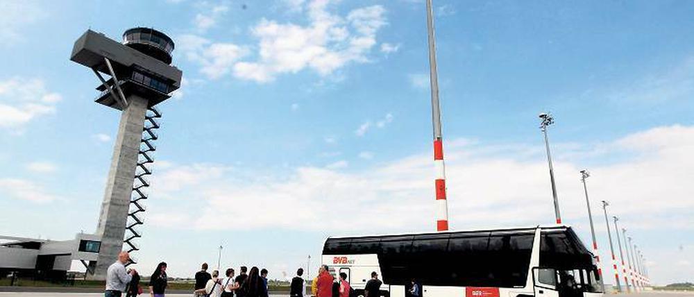 Bus statt Boeing. Irgendwann darf man hier zu Fuße des Towers – auf dem mit Handbesen grifffest geriffelten Boden, auf den mit Kristallen versetzten Markierungen – nicht mehr einfach so langspazieren. Am Sonnabend war wie hier bei den Billigfliegergates aber Baustellen-Gucken erlaubt.