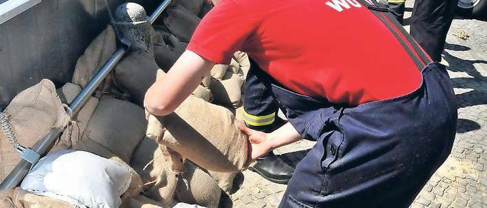 Sicherungsarbeiten. Mitarbeiter der Freiwilligen Feuerwehr stapeln in Wittenberge (Sachsen-Anhalt) Sandsäcke zur Sicherung der Deichanlagen.