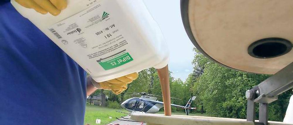 Spinnereinsatz. Ein Helicopter-Pilot befüllt in Potsdam einen Tank mit Dipel.
