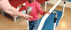 Laufen und lachen. Die kleine Clara im Physiotherapie-Raum der Klinik.