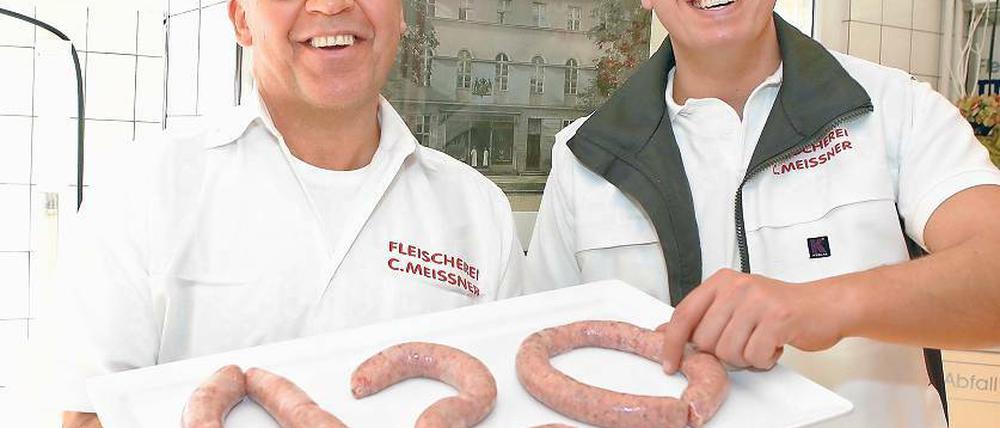 Vierte und fünfte Generation. Christian Meissner (li) und Sohn Clemens. Im Hintergrund ein Foto des Hauses mit dem ersten Ladengeschäft in der Breiten Straße, wo vor 120 Jahren alles begann. Heute gibt es in der Fleischerei Meissner nur Bio-Produkte.