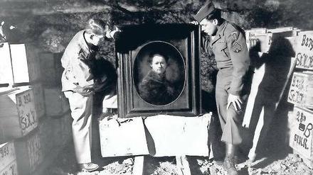 Entdeckung im Bergwerk Heilbronn. Monuments Men Dale V. Ford und Harry Ettlinger (v. l.) nehmen 1945 ein Selbstporträt Rembrandts in Augenschein, das Angestellte aus dem Museum Karlsruhe dort zur Sicherheit hingebracht hatten. Die Kisten links und rechts enthalten weitere Tausende von Kunstwerken, die in der Mine versteckt waren.