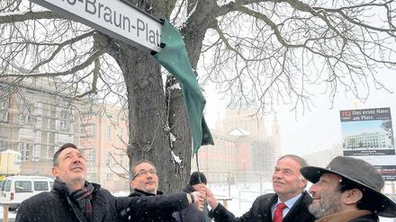 Enthüllung im Schnee. Oberbürgermeister Jann Jakobs, Ministerpräsident Matthias Platzeck, Landtagspräsident Gunter Fritsch und Stadtverordnetenpräsident Peter Schüler (v. l.) ziehen eine Abdeckung von dem Schild am neu benannten Otto-Braun-Platz.