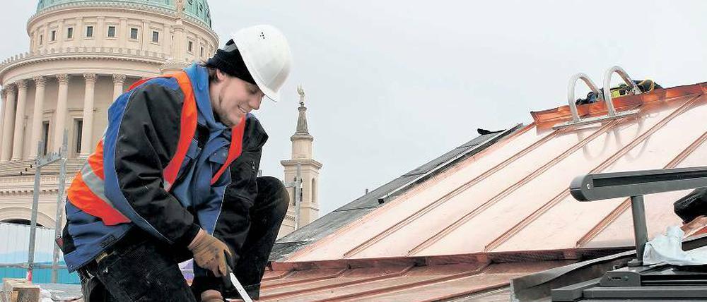 Immer obenauf. Dachdecker Manuel Strunk bei der Arbeit auf dem Dach des Landtagsschlosses. Mit einem Doppelfalzschließer verbindet der junge Handwerker die Kupferscharen miteinander. Das hält, sagt der 33-Jährige, „ziemlich ewig“.