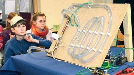 Staunend vor Heizschläuchen. Grundschüler der Bruno-H.-Bürgel-Schule in Babelsberg begutachten das Modell der Lenné-Gesamtschule, die ein intelligentes computergesteuertes Heizsystem entwickelt hat. Sie selbst haben dem Oberbürgermeister Jann Jakobs ihre im Unterricht genähten Stoffbeutel für die Partnerstadt Sansibar präsentiert.