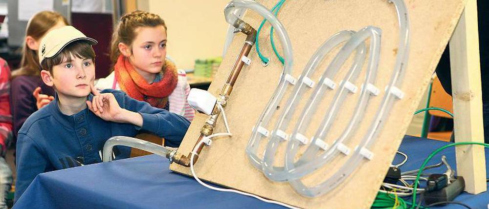 Staunend vor Heizschläuchen. Grundschüler der Bruno-H.-Bürgel-Schule in Babelsberg begutachten das Modell der Lenné-Gesamtschule, die ein intelligentes computergesteuertes Heizsystem entwickelt hat. Sie selbst haben dem Oberbürgermeister Jann Jakobs ihre im Unterricht genähten Stoffbeutel für die Partnerstadt Sansibar präsentiert.