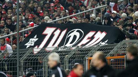 Im Cottbuser Fan-Block wird ein schwarzes Banner mit der weißen Aufschrift «Juden» hoch gehalten.