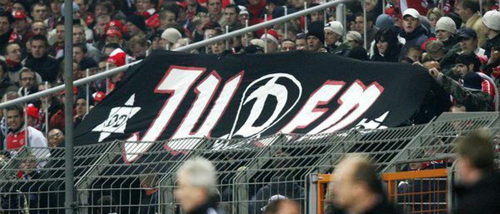 Im Cottbuser Fan-Block wird ein schwarzes Banner mit der weißen Aufschrift «Juden» hoch gehalten.