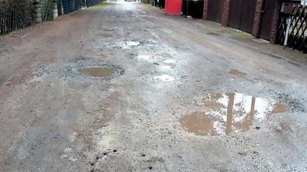 Löcher im Lehm. Der Wendensteig in Groß Glienicke ist eine Herausforderung für Achsen und Stoßdämpfer. Wegen des Lehmbodens hält sich nach Regenfällen das Wasser besonders lange in den Pfützen. Die Stadt kennt das Problem, hat jedoch derzeit keine Mittel, um die Straße auszubauen.
