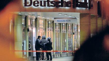 Anspannung. Polizisten eines Spezialeinsatzkommandos stehen am Freitag vor der Filiale der Deutschen Bank in Berlin-Zehlendorf. Ein bislang nicht identifizierter Mann hatte zuvor einen Bankangestellten als Geisel genommen und mit einer Bombe gedroht.