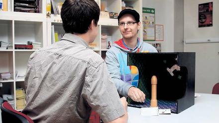 Mit Holzpenis zum Kondomführerschein. Marius B. (l.) ist für die Potsdamer Aidshilfe unter anderem bei der Bar-Tour in Kneipen unterwegs. Das Engagement hilft ihm, mit seiner eigenen HIV-Diagnose zu leben.