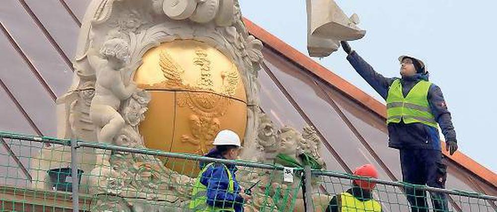 Wappen krönen Potsdams Schloss. Am Mittwoch begann der Einbau einer von insgesamt drei prunkvollen Wappenkartuschen nach historischem Vorbild. Nach der Pleite der Sächsischen Sandsteinwerke übernimmt eine fränkische Firma den Auftrag.