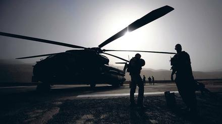 Wie lange noch im Krisengebiet? Soldaten der Bundeswehr stehen in Faisabad in Afghanistan vor einem Hubschrauber. Im Einsatzführungskommando in Geltow soll jetzt der Teilabzug aus Afghanistan koordiniert werden. Die Beelitzer Logistiker sind daran ebenfalls beteiligt.