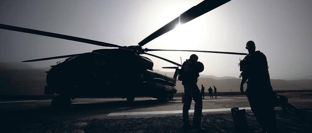 Wie lange noch im Krisengebiet? Soldaten der Bundeswehr stehen in Faisabad in Afghanistan vor einem Hubschrauber. Im Einsatzführungskommando in Geltow soll jetzt der Teilabzug aus Afghanistan koordiniert werden. Die Beelitzer Logistiker sind daran ebenfalls beteiligt.