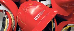 Rot sind nicht nur die Zahlen. Am Flughafen liegen die Bauhelme der Arbeiter. In wenigen Tagen soll es auf der Baustelle weitergehen. Eröffnung ist am 27. Oktober 2013.