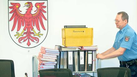 Komplexes Verfahren. Ein Justizmitarbeiter schiebt die Verfahrensakten in den Gerichtsaal. Den dringenden Tatverdacht sieht das Gericht nicht entkräftet.