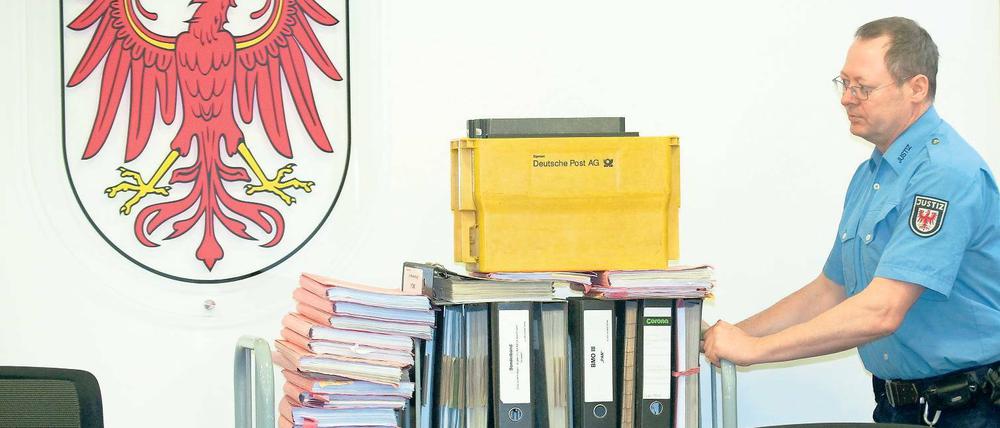 Komplexes Verfahren. Ein Justizmitarbeiter schiebt die Verfahrensakten in den Gerichtsaal. Den dringenden Tatverdacht sieht das Gericht nicht entkräftet.