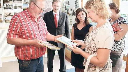 Auf Buch-Fühlung: Bei einem Besuch der russischen Delegation Anfang August überreichte Langerwischs Ortsvorsteher Wolfgang Kroll (l.) der Vize-Bürgermeisterin von Novoje Dewjatkino, Irina Kupina, einige Exemplare der Ortschronik.