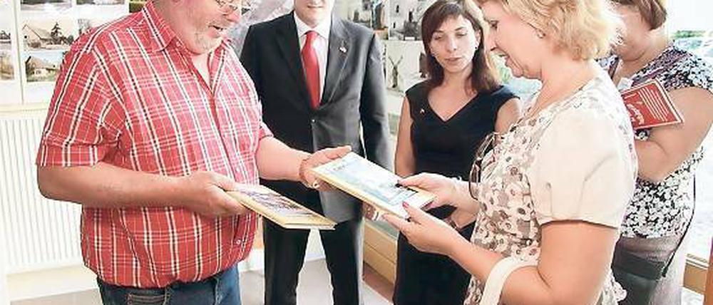 Auf Buch-Fühlung: Bei einem Besuch der russischen Delegation Anfang August überreichte Langerwischs Ortsvorsteher Wolfgang Kroll (l.) der Vize-Bürgermeisterin von Novoje Dewjatkino, Irina Kupina, einige Exemplare der Ortschronik.
