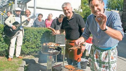 Vorzüglich. Jann Jakobs (r.) und Hans-Jürgen Scharfenberg grillen für die Gäste der Suppenküche auf dem Areal der Stadtverwaltung. Zuletzt beißen sie selbst in die Wurst.
