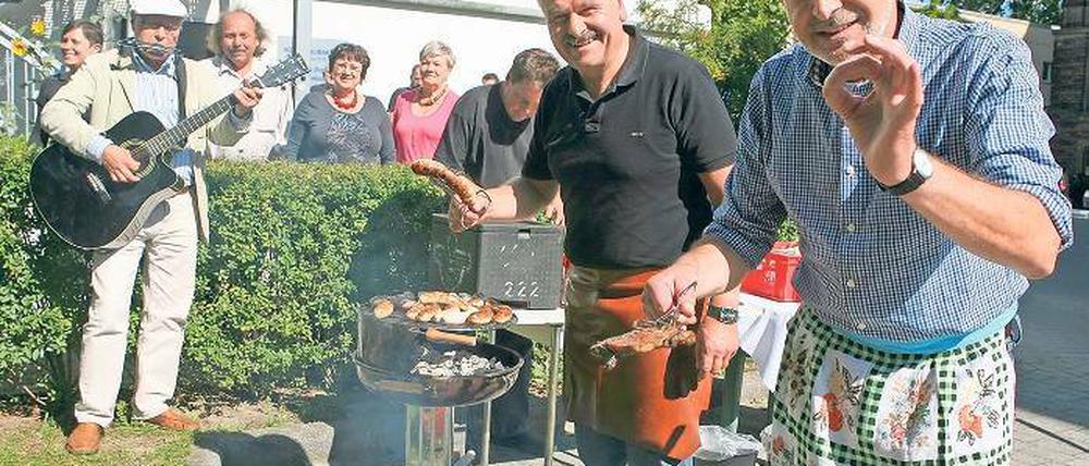 Vorzüglich. Jann Jakobs (r.) und Hans-Jürgen Scharfenberg grillen für die Gäste der Suppenküche auf dem Areal der Stadtverwaltung. Zuletzt beißen sie selbst in die Wurst.