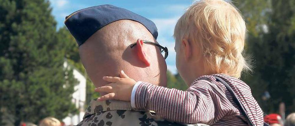 Noch einmal auf Papas Arm: Die Trennung über Monate ist eine der größten Belastungen für die Soldaten – und für ihre Familien.