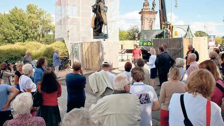 Eingehüllt. Als erstes soll der einzeln stehende Pylon (l.) der Kolonnaden der Glienicker Brücke restauriert werden. Dafür wurden am Montag im Beisein vieler Schaulustiger zunächst die beiden Sandsteinfiguren per Kran hinuntergehoben. Noch vor Winterbeginn sollen die 40 000 Euro teuren Arbeiten abgeschlossen sein.