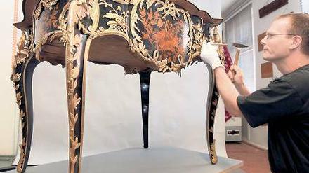 Restaurator Michael Wirth vor dem Schreibtisch Friedrichs des Großen.