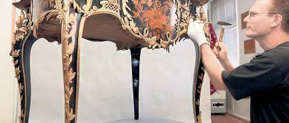 Restaurator Michael Wirth vor dem Schreibtisch Friedrichs des Großen.