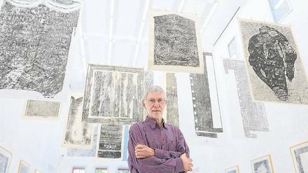 Abreibungen von Grabplatten aus St. Severi. Manfred Butzmann unter seinen Frottagen, aus der Erfurter St. Severikirche, die derzeit in einer Werkschau zu seinem 70. Geburtstag im Kunstmuseum Dieselkraftwerk in Cottbus zu sehen sind.