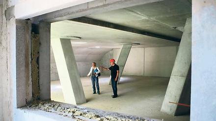 Filigrane Statik: Blick durch die Essensluke in den künftigen Speisesaal der Stadtteilschule Drewitz mit seinen markanten Stützpfeilern. Im Bild Anja Tefs vom Kommunalen Immobilien Service im Gespräch mit Linksfraktionschef Hans-Jürgen Scharfenberg.