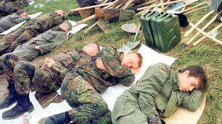 Schlafmangel. Nach 18 Stunden Dauereinsatz ruhen sich erschöpfte Bundeswehrsoldaten im Juli 1997 am Deich von Hohenwutzen aus. Insgesamt 30 000 Soldaten waren während der Hochwasserkatastrophe im Odergebiet im Einsatz.
