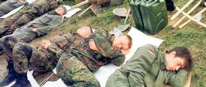 Schlafmangel. Nach 18 Stunden Dauereinsatz ruhen sich erschöpfte Bundeswehrsoldaten im Juli 1997 am Deich von Hohenwutzen aus. Insgesamt 30 000 Soldaten waren während der Hochwasserkatastrophe im Odergebiet im Einsatz.
