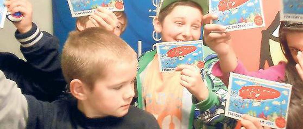 Vorfreude. Die Kinder im Kinderclub „Unser Haus“ wollen mit dem Ferienpass in den Sommer starten. Der kostenlose Pass mit 15 Gutscheinen wirbt außerdem für 170 Freizeitangebote in Potsdam und Berlin.