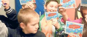 Vorfreude. Die Kinder im Kinderclub „Unser Haus“ wollen mit dem Ferienpass in den Sommer starten. Der kostenlose Pass mit 15 Gutscheinen wirbt außerdem für 170 Freizeitangebote in Potsdam und Berlin.