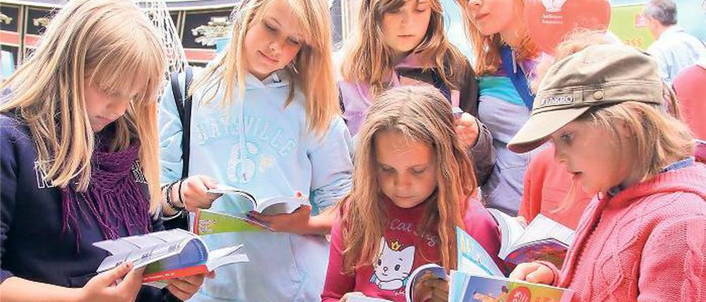 Erstes Schmökern. Schüler studieren den neuen Familienpass.