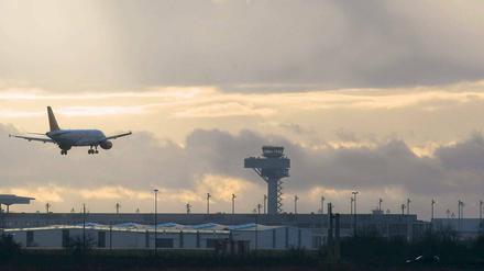 Noch außer Betrieb. Ein Passagierflugzeug landet auf dem alten Flughafen Schoenefeld. Im Hintergrund ist der Tower des zukünftigen Flughafens Berlin-Brandenburg Willy Brandt zu sehen. Noch allerdings steht die Betriebserlaubnis für den BER aus.