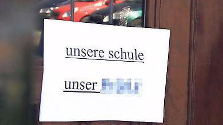 Protest. Sowohl am als auch im Schulhaus hängen Zettel und Plakate.