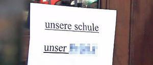 Protest. Sowohl am als auch im Schulhaus hängen Zettel und Plakate.