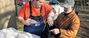 Vorrat für wenige Tage. Rainer Zingel (r.) hat sich wie viele andere Tremsdorfer am Wochenende mit Trinkwasserbeuteln eingedeckt. Das Wasser aus der Leitung schmeckt muffig. Wassermeister Andreas Roos (l.) hofft auf weitere Analyseergebnisse.