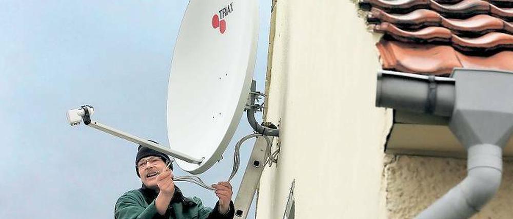 Damit der Bildschirm nicht schwarz wird. Fernsehtechniker Detlef Behrendt ist derzeit täglich in Potsdam im Einsatz, um analoge Satellitenanlagen umzurüsten. Wer wissen will, ob man in neue Empfangstechnik investieren muss, sollte auf Regen warten.