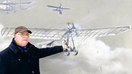 Vor hundert Jahren hob die „Libelle“ ab: Burkhard Ballin, Vorsitzender der Hans-Grade-Gesellschaft, vor einem Motiv eines der ersten Hans-Grade-Flugzeuge.