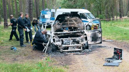 Grausiger Fund. Das ausgeglühte Auto wurde bei Börnicke gefunden. Polizisten sperrten das Areal ab.